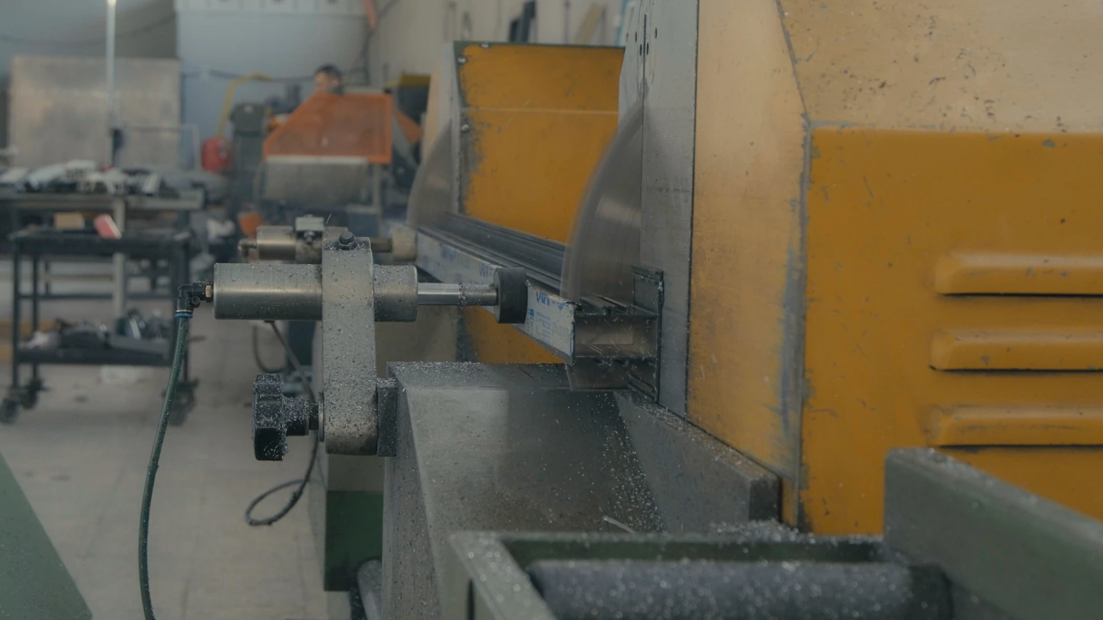 Industrial saw cutting metal in a manufacturing workshop