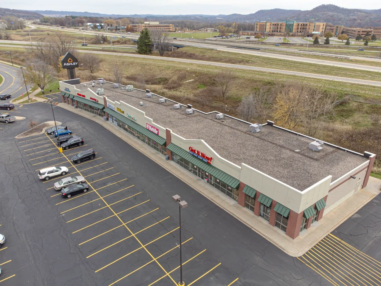 Small retail center with multiple storefronts and a parking area